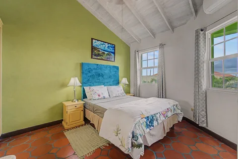 Double bedroom with green feature wall in the two-bedroom Prospect villa