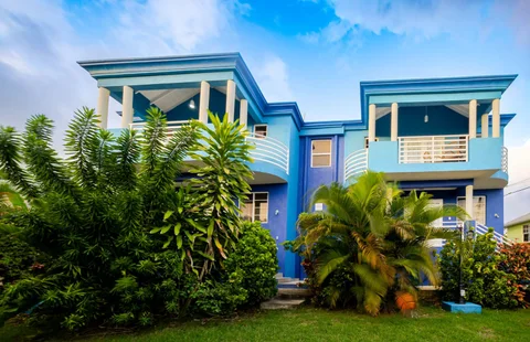 Front view of the blue St. Silas villas and garden